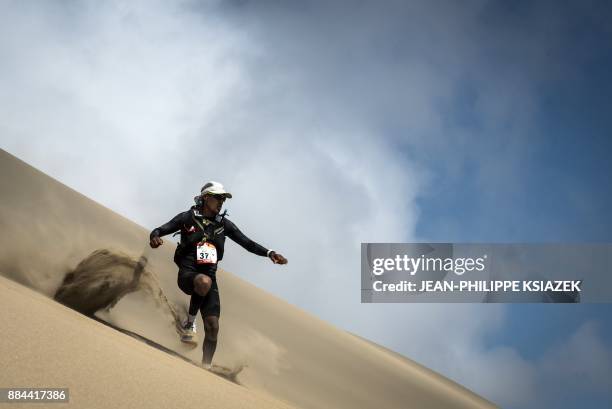 Competitor takes part in the fourth stage of the first edition of the Marathon des Sables Peru between Ocucaje and Barlovento on December 1 in the...