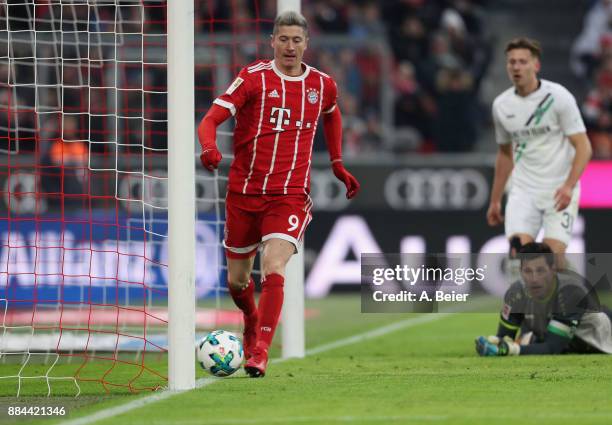 Robert Lewandowski of FC Bayern Muenchen scores his first goal against goalkeeper Philipp Tschauner of Hannover 96 during the Bundesliga match...