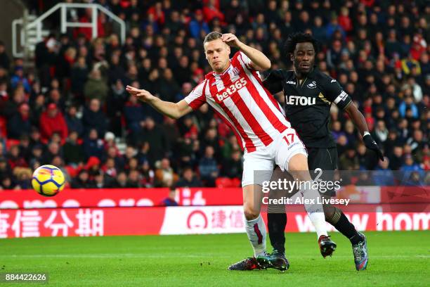 Wilfried Bony of Swansea City scores his sides first goal as Ryan Shawcross of Stoke City attempts to challenge during the Premier League match...