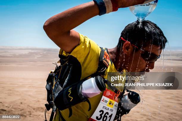Competitor pours water on his head as he takes part in the fourth stage of the first edition of the Marathon des Sables Peru between Ocucaje and...