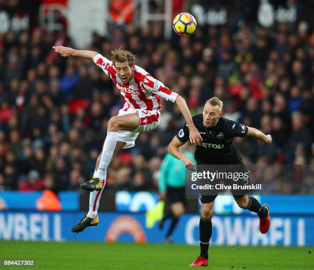 Peter Crouch of Stoke City and Mike van der Hoorn of Swansea City during the Premier League match between Stoke City and Swansea City at Bet365...