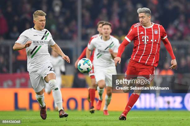 Robert Lewandowski of Bayern Muenchen runs with Matthias Ostrzolek of Hannover during the Bundesliga match between FC Bayern Muenchen and Hannover 96...