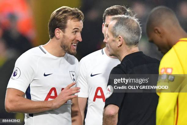 Tottenham Hotspur's English striker Harry Kane talks with referee Martin Atkinson after he sent off Tottenham Hotspur's Colombian defender Davinson...