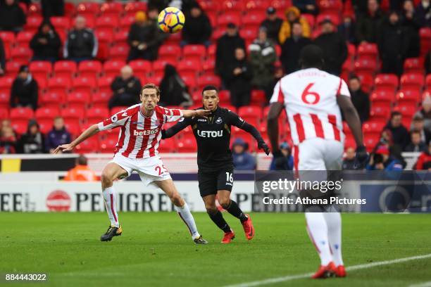 Martin Olsson of Swansea City is marked by Peter Crouch of Stoke City during the Premier League match between Stoke City and Swansea City at the...