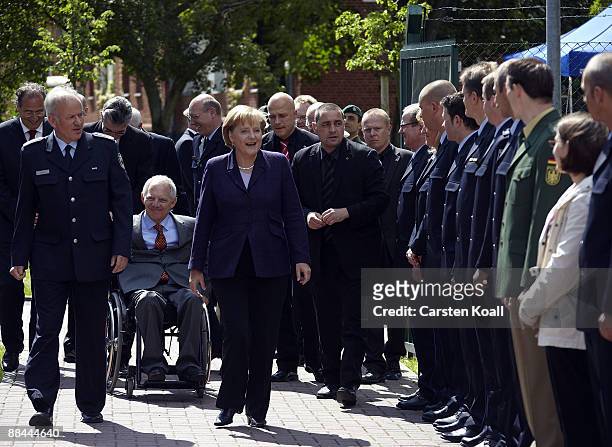 German Chancellor Angela Merkel and German Interior Minister Wolfgang Schaeuble are welcomed by Federal Police President Matthias Seeger as they...