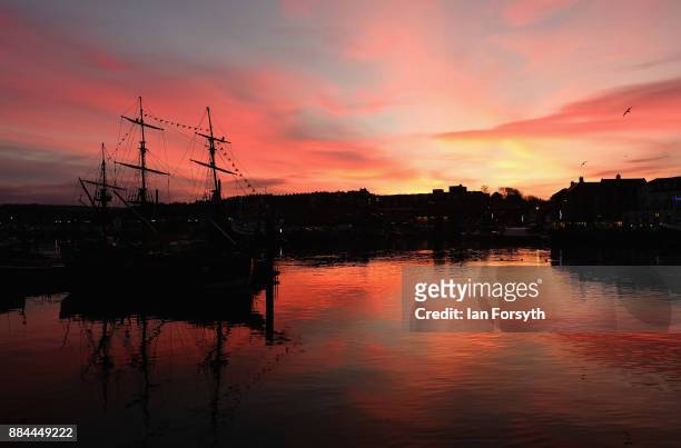 The sky turns red as the sun sets over Whitby Harbour on December 2, 2017 in Whitby, England. The popular North Yorkshire seaside town enjoys a mild...