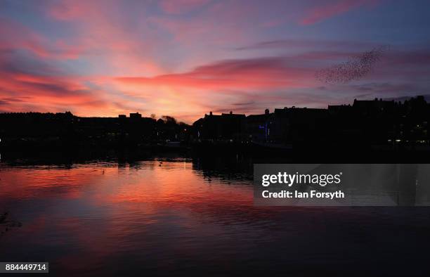 The sky turns red as the sun sets over Whitby Harbour on December 2, 2017 in Whitby, England. The popular North Yorkshire seaside town enjoys a mild...