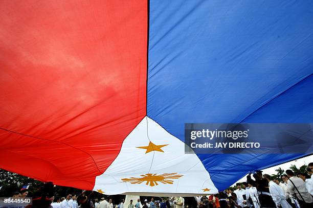 Government officials lead a flag-raising ceremony at Manila's Luneta park on June 12 to celebrate the 111th anniversary of the declaration of...