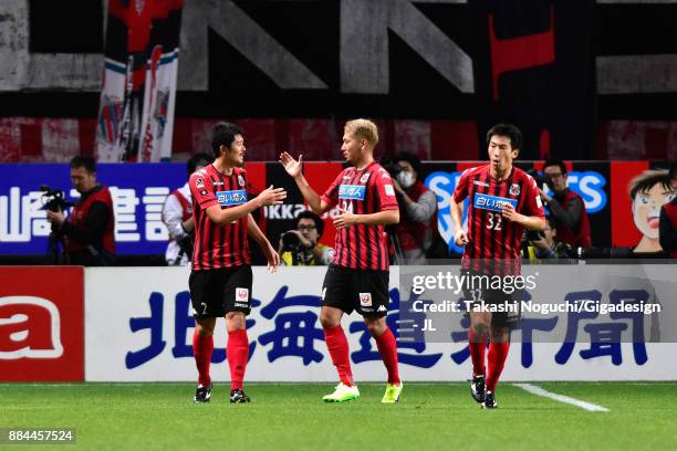 Tomonobu Yokoyama of Consadole Sapporo celebrates scoring his side's third goal with his team mates Akito Fukumori and Naoki Ishikawa during the...