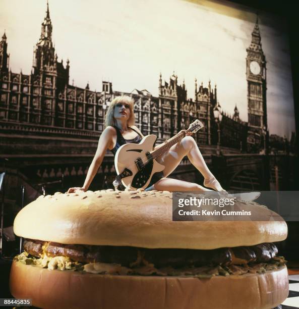 American guitarist Brix Smith, of rock group The Fall, poses on a giant hamburger from the set of the ballet 'I Am Kurious Oranj', performed by...