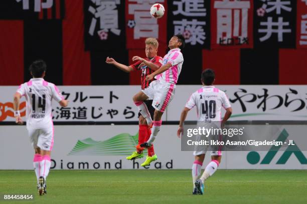 Akito Fukumori of Consadole Sapporo and Kei Ikeda of Sagan Tosu compete for the ball during the J.League J1 match between Consadole Sapporo and Sagan...