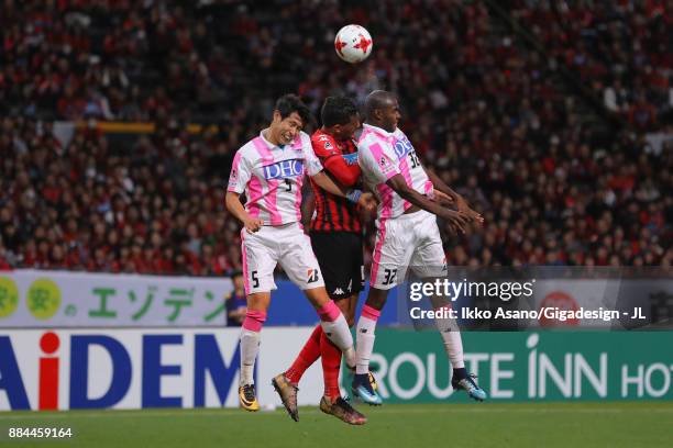 Jay Bothroyd of Consadole Sapporo competes for the ball against Kim Min Hyeok and Victor Ibarbo of Sagan Tosu during the J.League J1 match between...
