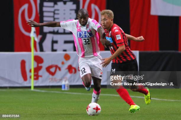 Akito Fukumori of Consadole Sapporo and Victor Ibarbo of Sagan Tosu compete for the ball during the J.League J1 match between Consadole Sapporo and...