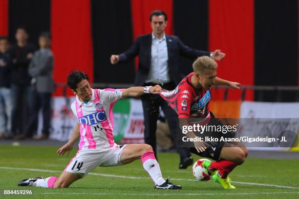 Akito Fukumori of Consadole Sapporo and Yoshiki Takahashi of Sagan Tosu compete for the ball during the J.League J1 match between Consadole Sapporo...