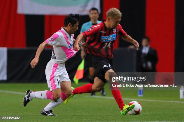 Akito Fukumori of Consadole Sapporo and Yoshiki Takahashi of Sagan Tosu compete for the ball during the J.League J1 match between Consadole Sapporo...