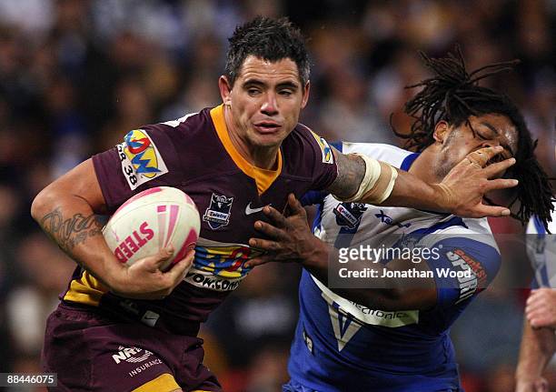 Corey Parker of the Broncos fends off a tackle from Jamal Idris of the Bulldogs during the round 14 NRL match between the Brisbane Broncos and the...