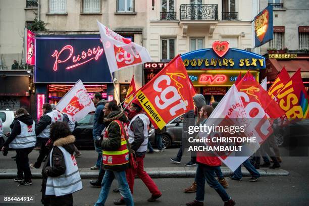 People walk past sex shops in the Pigalle district of Paris, during a demonstration against unemployment and precarious work on December 2 called by...