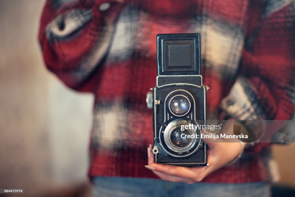 Close up of young woman with vintage camera