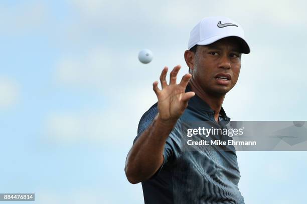 Tiger Woods of the United States catches a ball as he warms up on the range prior to the third round of the Hero World Challenge at Albany, Bahamas...