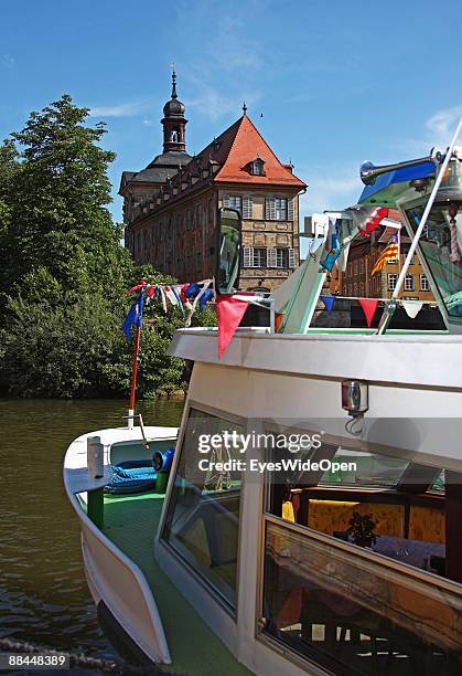 Tourist boat and the former City Hall at the river Regnitz with its facade in rococo style on June 11, 2009 in Bamberg, Germany. Bamberg is listed as...