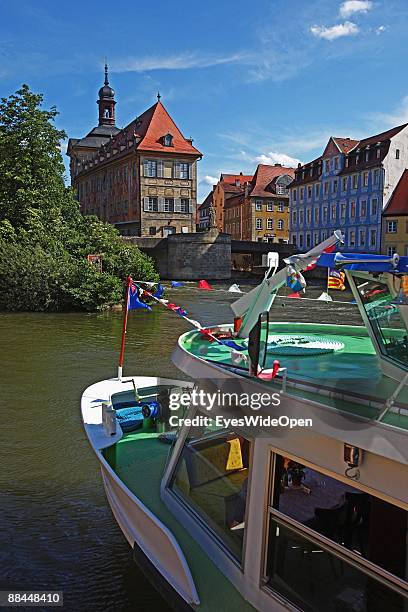 Tourist boat and the former City Hall at the river Regnitz with its facade in rococo style on June 11, 2009 in Bamberg, Germany. Bamberg is listed as...