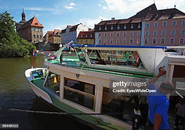 Tourist boat and the former City Hall at the river Regnitz with its facade in rococo style on June 11, 2009 in Bamberg, Germany. Bamberg is listed as...