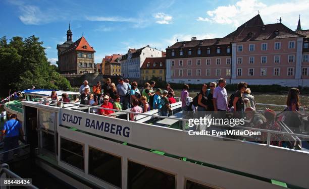 Tourist boat and the former City Hall at the river Regnitz with its facade in rococo style on June 11, 2009 in Bamberg, Germany. Bamberg is listed as...