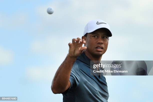 Tiger Woods of the United States catches a ball as he warms up on the range prior to the third round of the Hero World Challenge at Albany, Bahamas...