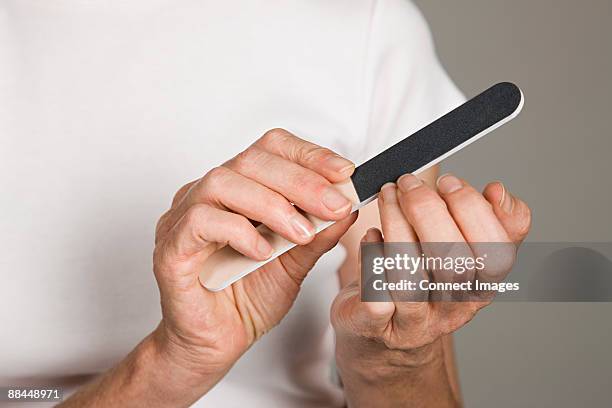 woman filing her nails - nagelfeile stock-fotos und bilder