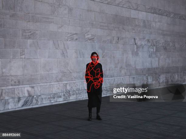 woman entangled with neon wires against urban marble background - woman stuck stock pictures, royalty-free photos & images