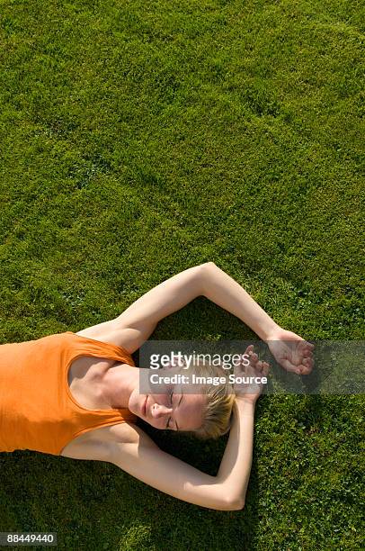 woman lying on grass - laying on grass stock pictures, royalty-free photos & images