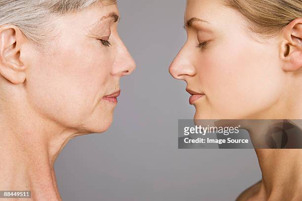 young and senior women face to face - side profile face to face stock-fotos und bilder