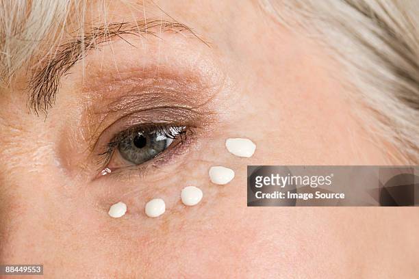 woman with eye cream - compassionate eye stock pictures, royalty-free photos & images