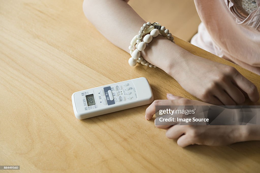 Woman with air conditioning remote control