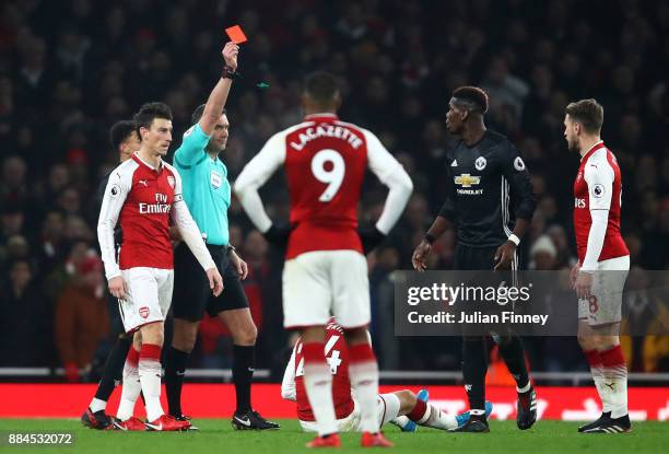 Paul Pogba of Manchester United is shown a red card by referee Andre Marriner for stamping on Hector Bellerin of Arsenal during the Premier League...