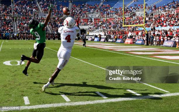 Kalib Woods of the Florida Atlantic Owls makes a reception in the red zone past Nate Brooks of the North Texas Mean Green during the Conference USA...