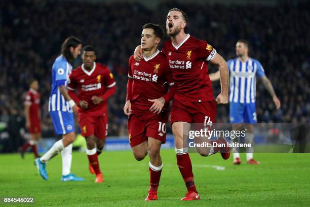Philippe Coutinho of Liverpool celebrates with team-mates including Jordan Henderson after scoring his team's fourth goal during the Premier League...