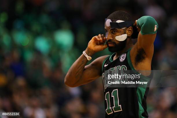 Kyrie Irving of the Boston Celtics adjusts his face mask during the second half against the Phoenix Suns at TD Garden on December 2, 2017 in Boston,...