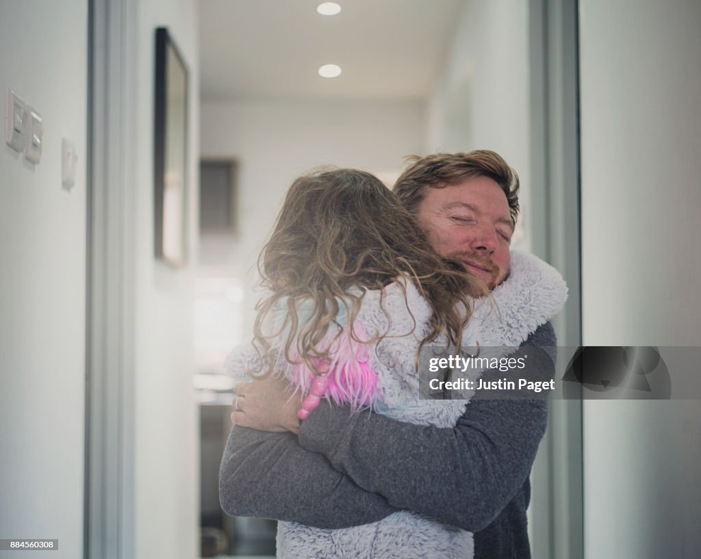 Father giving a big cuddle to young daughter