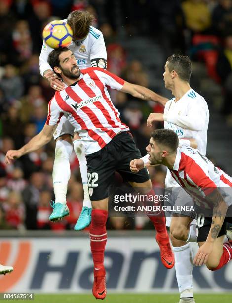 Real Madrid's Spanish defender Sergio Ramos heads the ball with Athletic Bilbao's Spanish midfielder Raul Garcia during the Spanish league football...