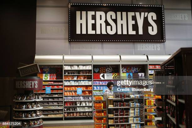 Shopper walks past Hershey Co. Candies displayed for sale inside of the company's Chocolate World visitor center in Hershey, Pennsylvania, U.S., on...