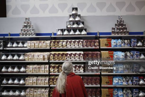 Shopper browses packages of Hershey Co. Kisses candies displayed for sale inside of the company's Chocolate World visitor center in Hershey,...