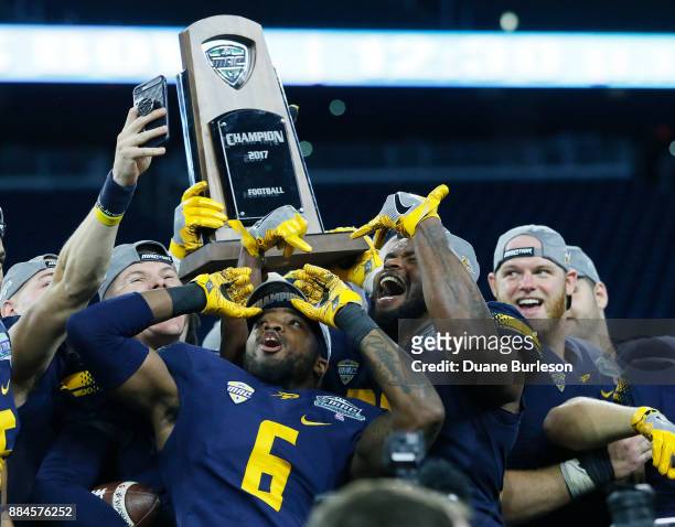 Cornerback Trevon Mathis of the Toledo Rockets and linebacker Ja'Wuan Woodley of the Toledo Rockets celebrate with teammates and the MAC Championship...
