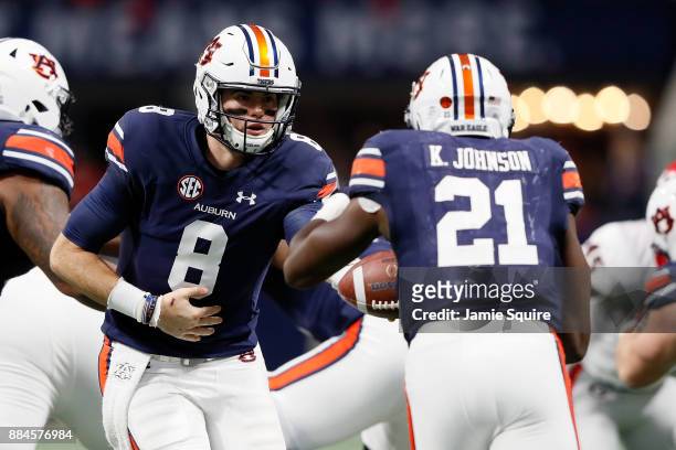 Jarrett Stidham of the Auburn Tigers hands off to Kerryon Johnson during the first half against the Georgia Bulldogs in the SEC Championship at...