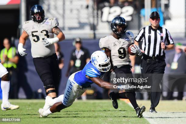 Running back Adrian Killins Jr. #9 of the UCF Knights gets a big first down in the third quarter of the ACC Championship against the Memphis Tigers...