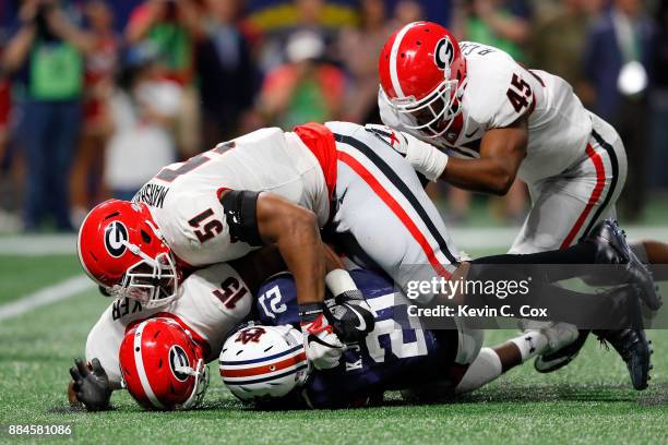 Kerryon Johnson of the Auburn Tigers is tackled by D'Andre Walker and David Marshall of the Georgia Bulldogs during the first half in the SEC...