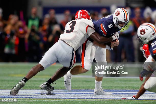 Jarrett Stidham of the Auburn Tigers is tackled by Roquan Smith of the Georgia Bulldogs during the first half in the SEC Championship at...