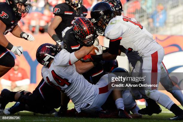 Kyle Wagner of the Eaglecrest Raptors and Victor Garnes force a fumble on Max Borghi of Pomona Panthers during the first half of of the Colorado...