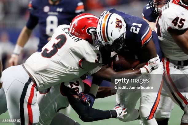 Kerryon Johnson of the Auburn Tigers is tackled by Roquan Smith of the Georgia Bulldogs during the second half in the SEC Championship at...