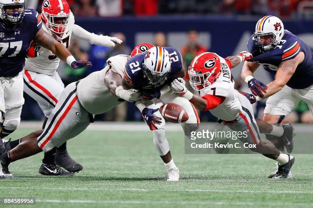 Kerryon Johnson of the Auburn Tigers fumbles when tackled by Lorenzo Carter and Julian Rochester of the Georgia Bulldogs during the second half in...